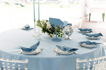 Floral table decoration for holidays and weddings. Wedding travelers, tourists. A set table for a celebration, event, party or wedding in an outdoor restaurant. Soft selective focus.