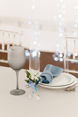 Table setting for holidays and wedding, blue color. A set table for a celebration, event, party or wedding in an outdoor restaurant. Soft selective focus.