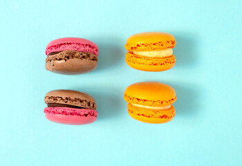 Cake macaron or macaroon on turquoise background from above, colorful almond cookies, pastel colors, vintage card