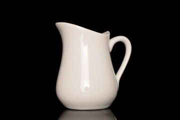 One ceramic milk jug, close-up, isolated on a black background.