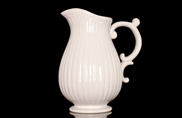 One ceramic milk jug, close-up, isolated on a black background.