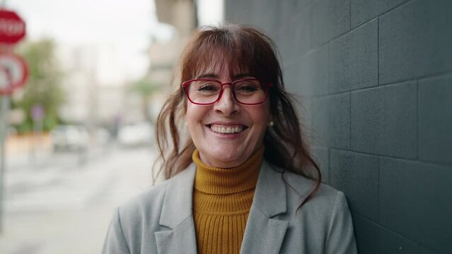 Middle age woman business executive smiling confident at street