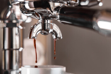 Espresso dripping out of a professional machine