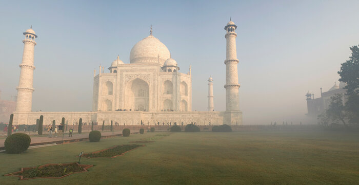 India, Agra, Panoramic view of Taj Mahal in early morning light with ground fog