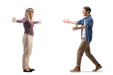 Full length profile shot of a young man and woman meeting each other with open arms
