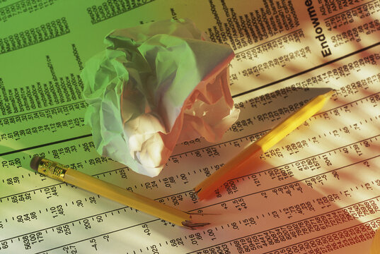 Pencils and crumpled paper on stock listings