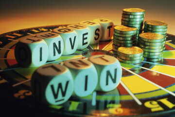 Close-up of lettered cubes and stacks of coins on a dartboard
