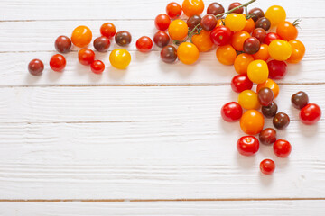 Fototapeta na wymiar various tomatoes on white wooden background