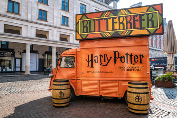 Naklejka premium Orange food and drink truck selling Butterbeer, in Covent Garden, London. This drink was make famous and popular by the Harry Potter film franchise.