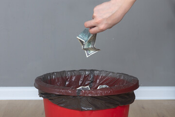 Throw fake dollar bills in the trash in the trash bucket