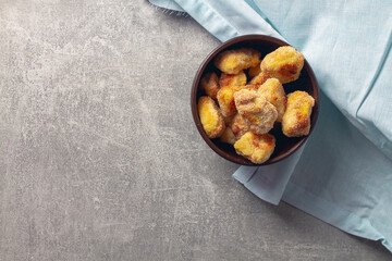 Ready-made homemade nuggets in a brown clay bowl on a blue napkin background
