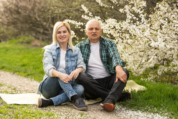 Senior man embraced by his adult daughter, outdoors.