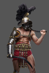 Shot of antique roman gladiator dual wielding swords in combative pose isolated on gray.