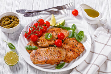 tomato basil pesto fried pork cutlets on plate