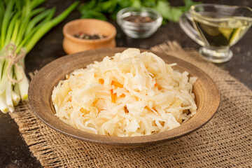 Sauerkraut with carrots in a bowl. Fermented food. Homemade food. Pickled food. Pickled vegetables. Vegetarian vegan food. Side view .