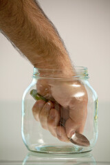 Hand in jar holding spoon