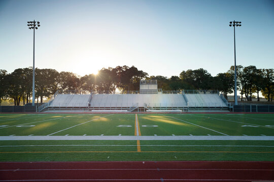 Field level view of a high school track and football field in Texas at sunrise