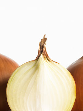 Close up of onion cut in half and whole ones behind