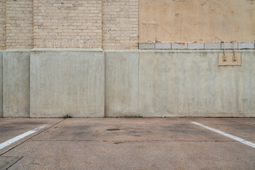 urban texture and background - old gray grunge building wall and concrete pavement with some green...