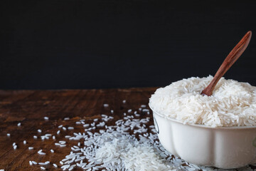 White raw rice in a bowl on a wooden table