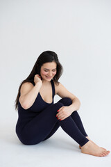 Young beautiful woman practicing yoga on a white background. Young beautiful girl doing exercises at home. Harmony, balance, meditation, relaxation, healthy lifestyle concept 