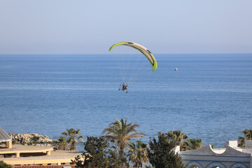 motor paraglider flies over the sea