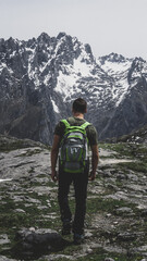 One person from behind hiking with the snowy mountains in the background