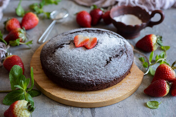 Breakfast for the whole family: delicious chocolate cake with strawberry slices on a gray background. Close-up.