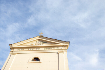 Church Against Heaven. Low Angle View of Beautiful Historic Church with Cross on Top Against Blue...