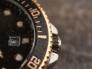 Men's wrist watch with gilded bezel under water drops