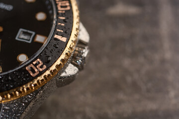Men's wrist watch with gilded bezel under water drops