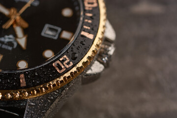 Men's wrist watch with gilded bezel under water drops