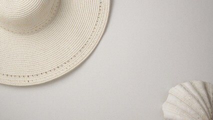 Fototapeta na wymiar Beautiful summer all white minimal flat lay. Female sun hat and a shell. Space for text. Traveling holiday destination concept.