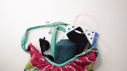 Summer flat lay of things that fall out of a beach bag on a white background. Traveling destination sun, fun and sea concept. Copy text.