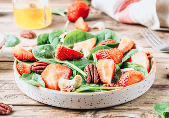 Fresh strawberry salad with spinach leaves and nuts.