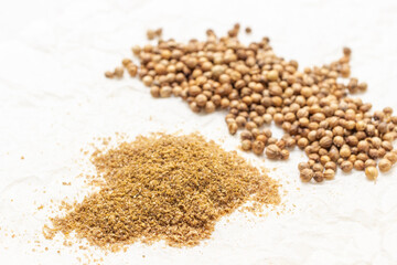 Ground coriander and coriander seeds and  on the table.