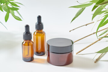 Brown glass bottles of cosmetics and jar on a light background. Concept  organic natural cosmetic products for skincare