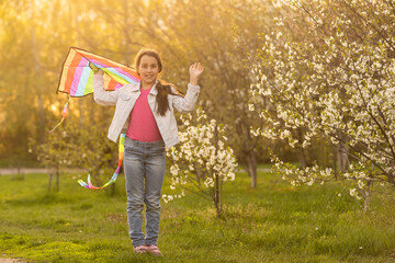 Obraz premium happy child girl with a kite running on meadow in nature.