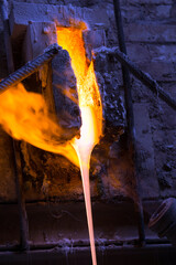 Melted glass furnace in glass factory.The melted glass flows from the furnace in a glass factory.