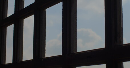Movement silhouette of black bars of the lattice on the background of the sky. View from the eyes of a prisoner in prison. White clouds, look into the distance. Relaxation of the psyche.
