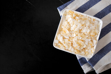 White plate with coconut flakes on a striped towel. Food on the table. vegan food