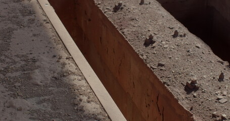 Movement of concrete floors in sunlight in dust and dirt. deep holes in between. Industrial engineering building. Metal border steps.