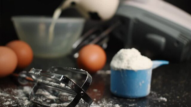 Milk, flour, eggs and blender stuff on a black table in the kitchen 
