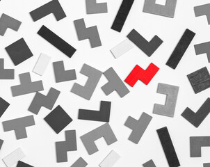 puzzle black and white pieces with outstanding red one. Uniqueness, standing out from crowd, individuality concept. High quality photo