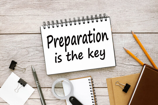PREPARATION IS THE KEY notebook on the table with text