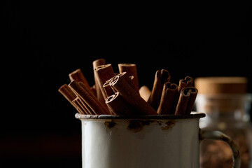 dry brown cinnamon sticks in a metal old mug, culinary spice