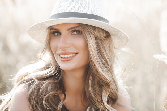 Young attractive woman in the hat. Closeup portrait of beautiful woman outdoors. Pretty lady smiling