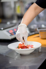 The chef in the kitchen spreads feta cheese and prepares a Greek salad. Concept of сooking vegetarian salad