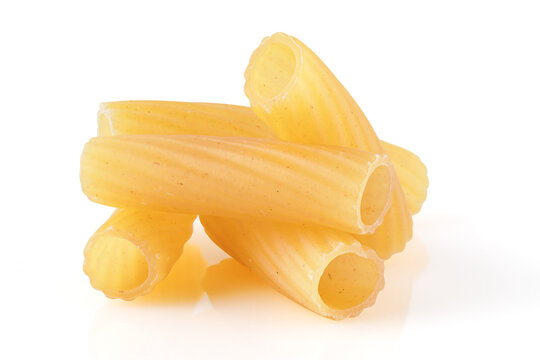 Uncooked pasta tubes, tortiglioni or elicoidali isolated on white background, top view. Close-up.