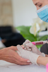 A woman is getting a manicure of nails